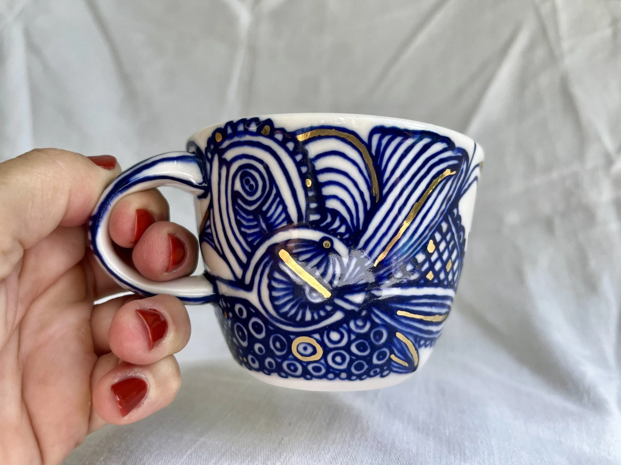Porcelain mug No. 031 held in hand to show its size