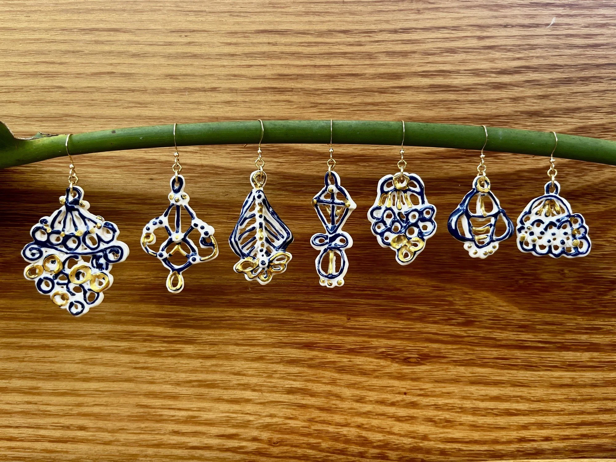 Handmade porcelain earrings with cobalt blue line work and gold luster detail