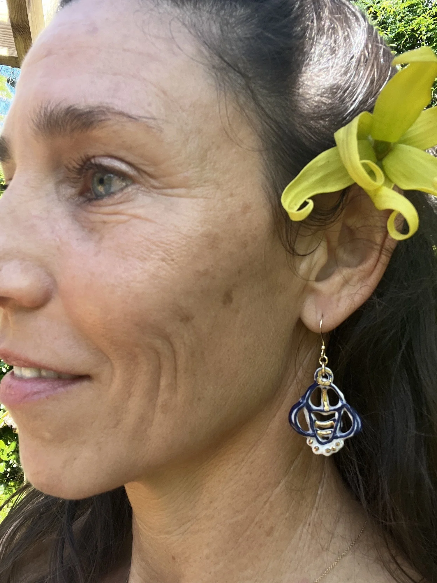 Porcelain earring No. 006 in cobalt blue and gold luster worn on the ear