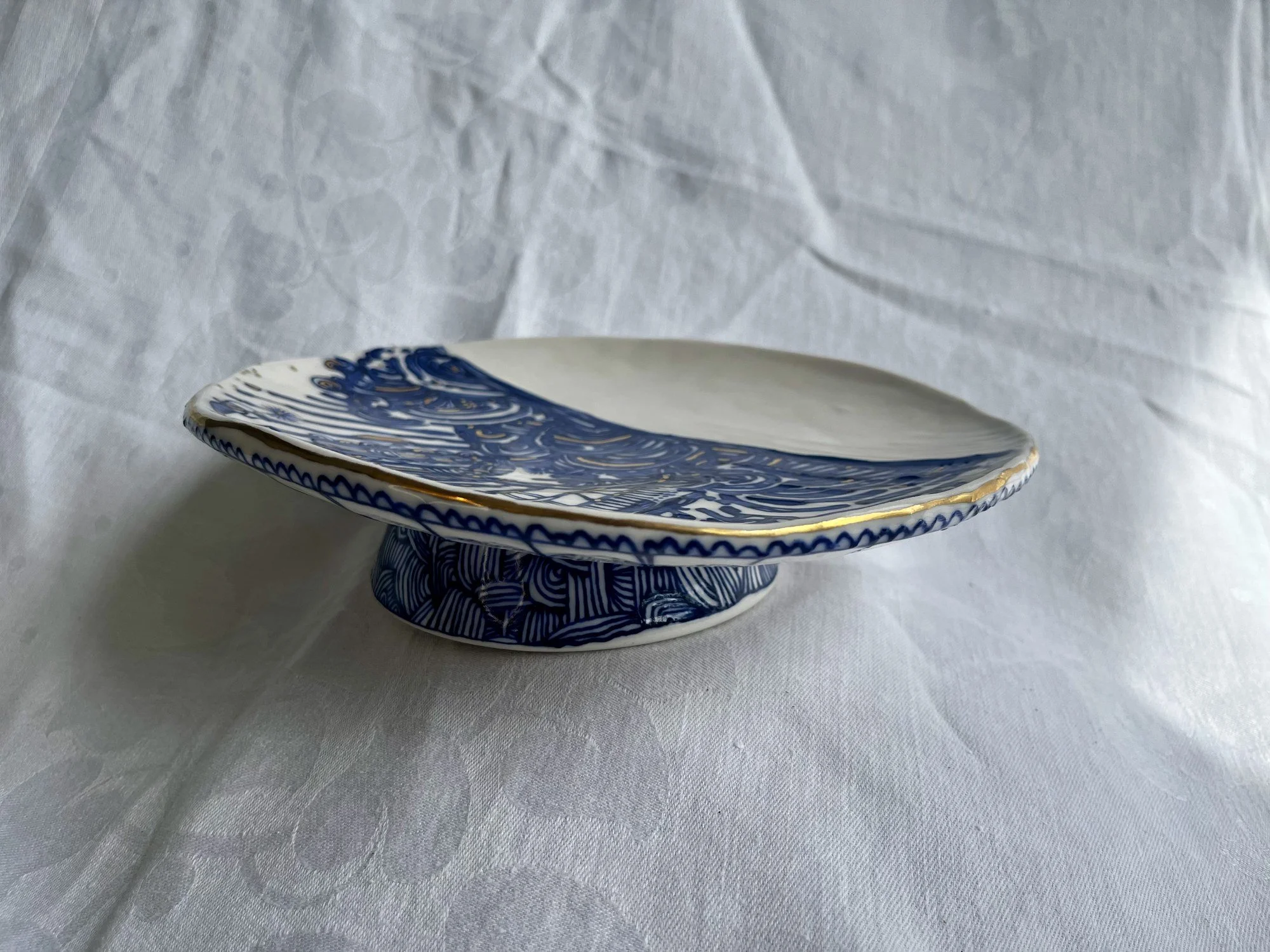 Hand-thrown porcelain footed serving dish in cobalt blue and gold luster by Cypress Knees Ceramics