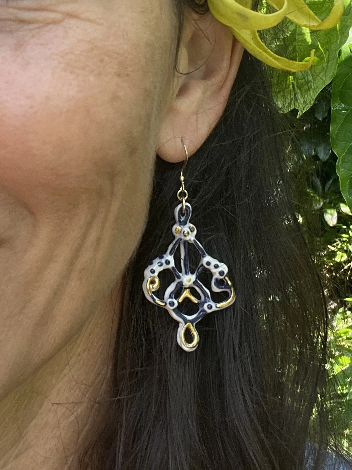 Porcelain earring No. 004 in cobalt blue and gold luster worn on the ear