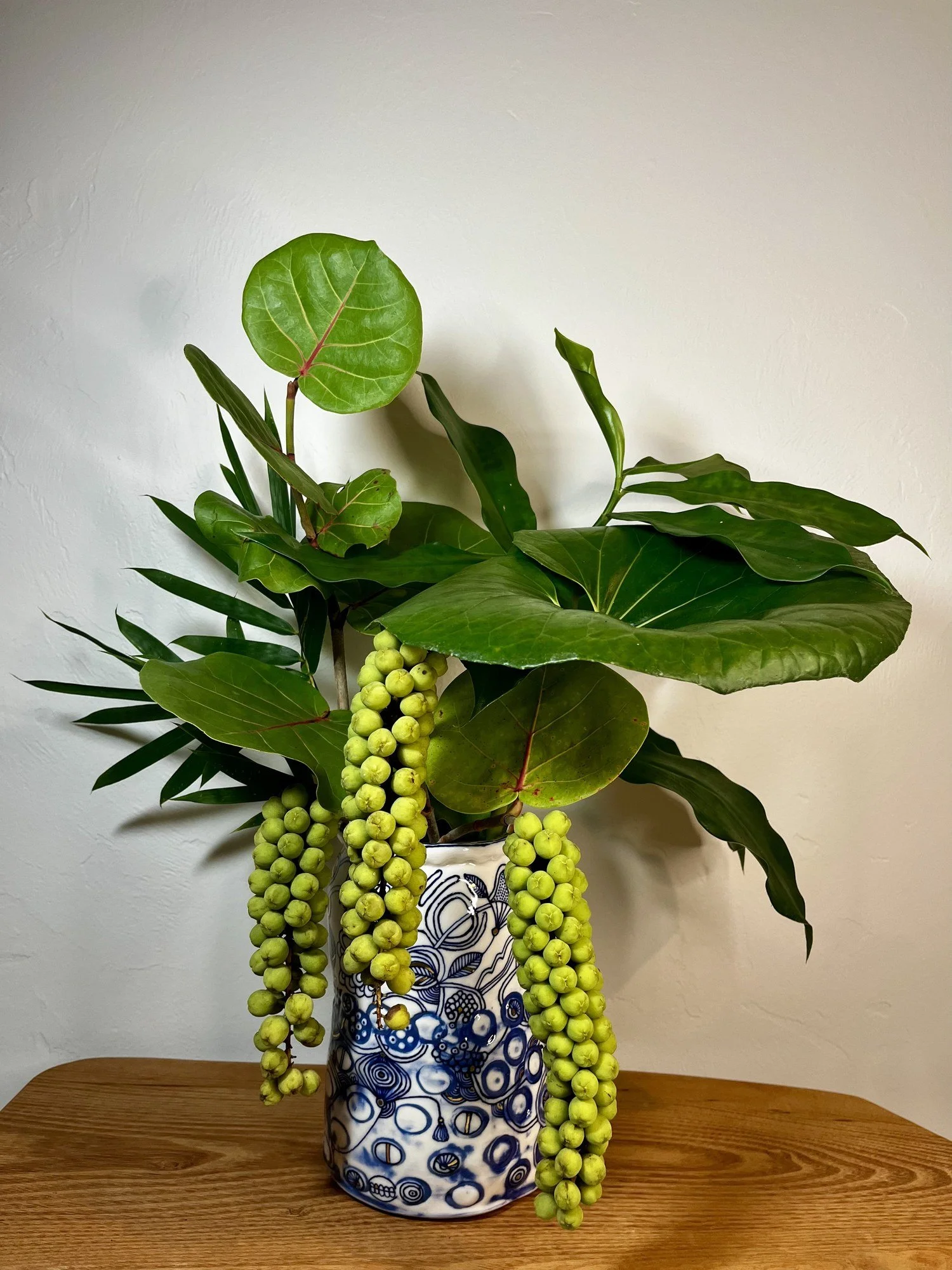 Porcelain vase No. 001 holding a fresh green arrangement on a wood table