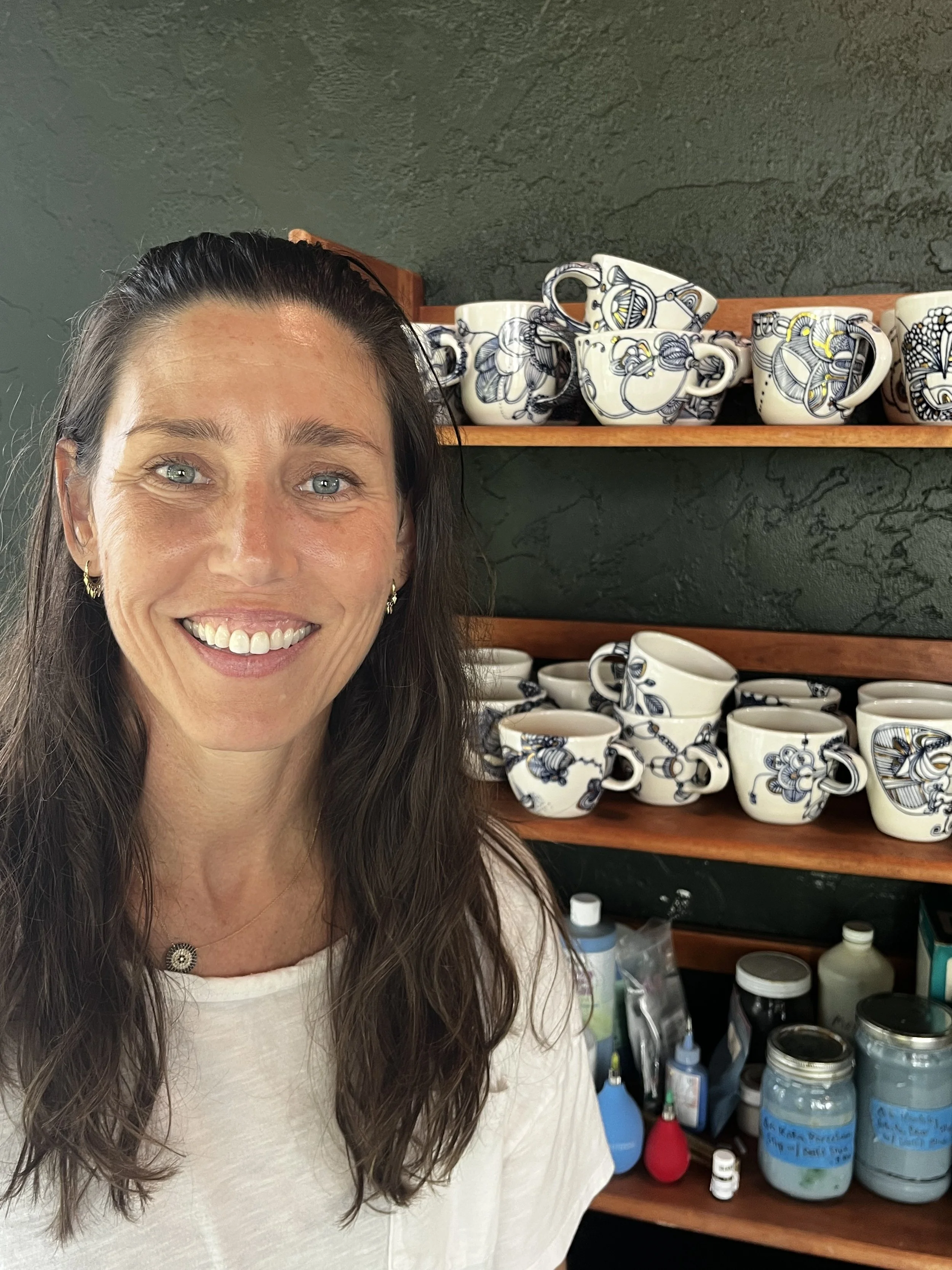 Lana, potter and founder of Cypress Knees Ceramics, in her Naples, Florida studio with hand-painted porcelain mugs