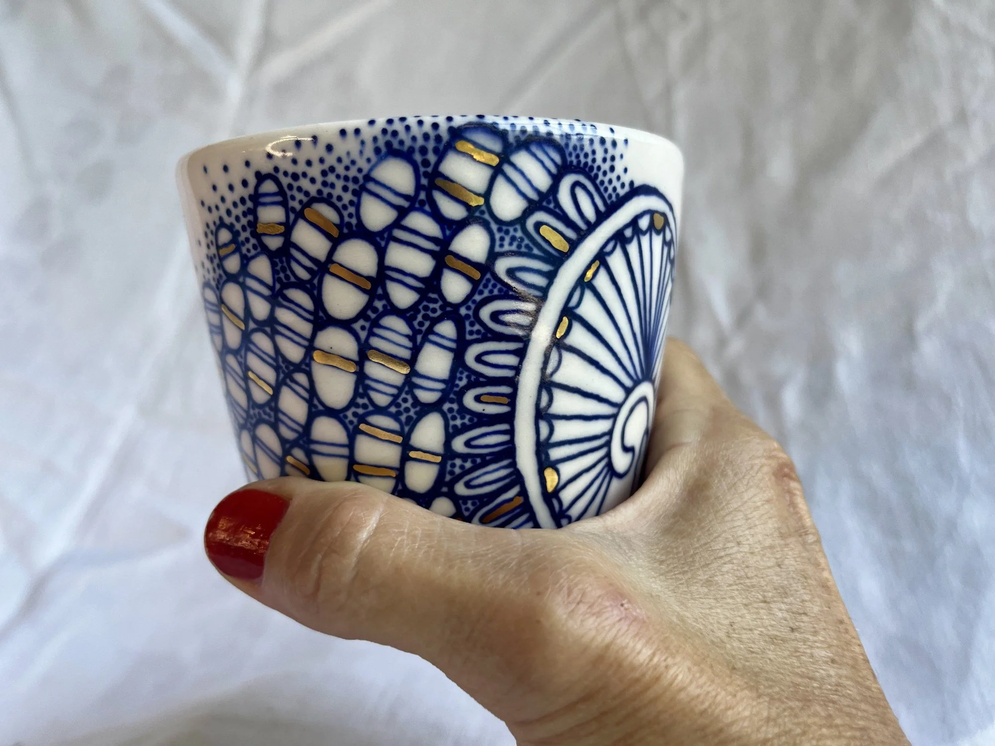 Handleless porcelain tumbler No. 001 held in hand to show its size
