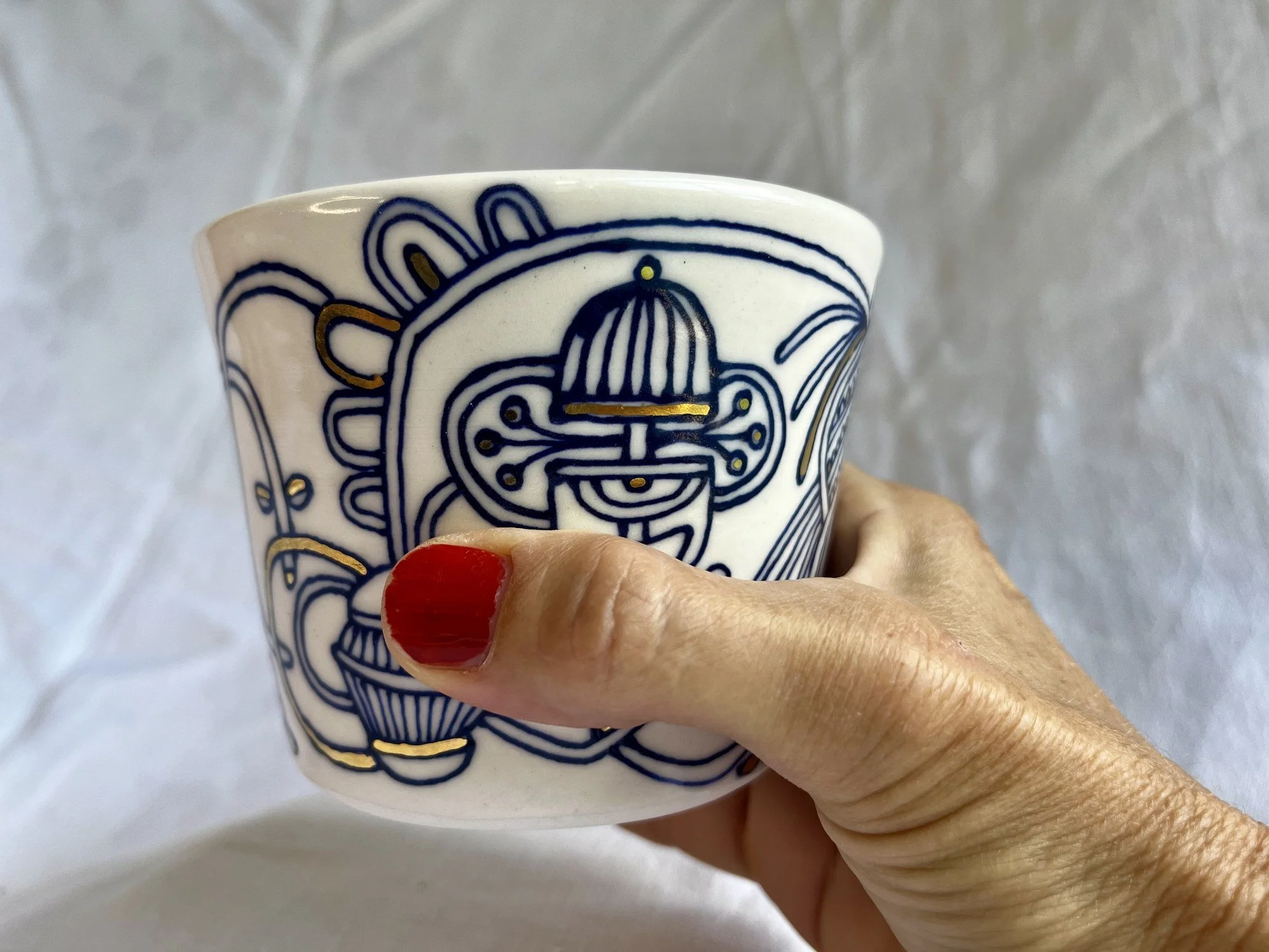 Handleless porcelain tumbler No. 002 held in hand to show its size