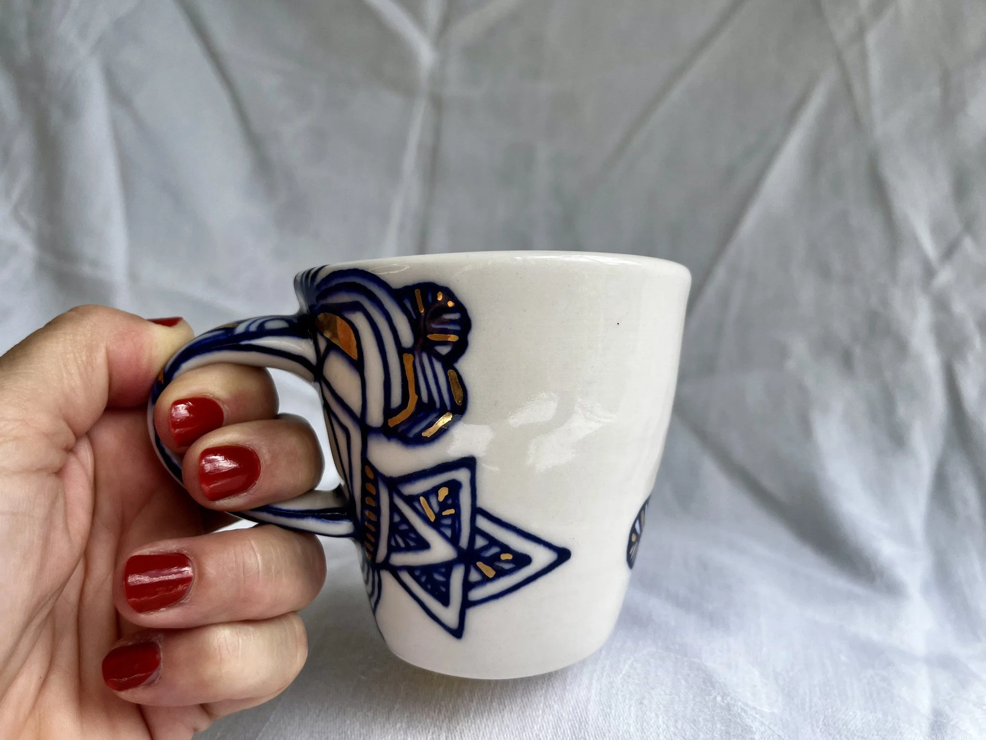Porcelain mug No. 028 held in hand to show its size