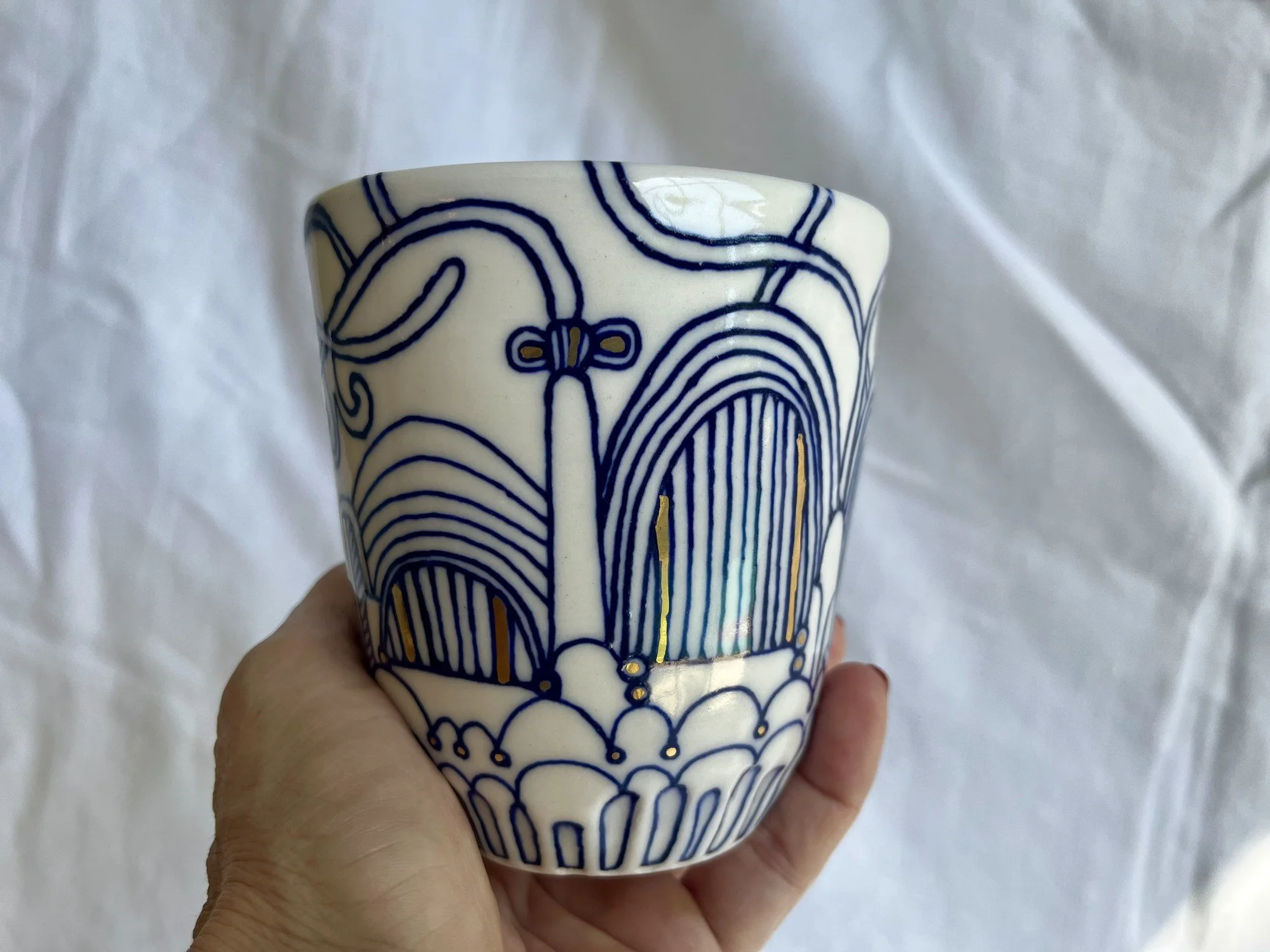 Handleless porcelain tumbler No. 003 held in hand to show its size