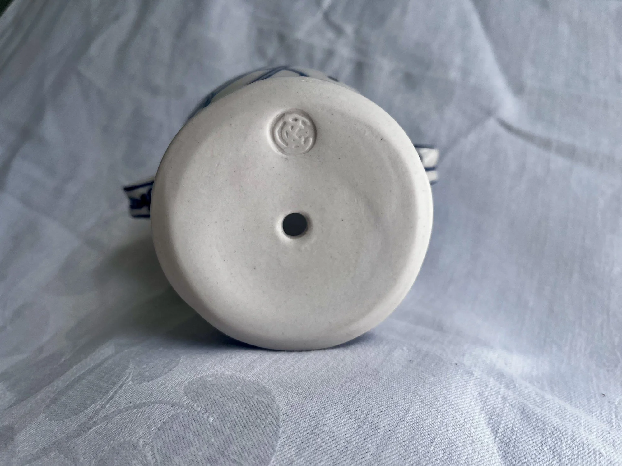 Base of handmade porcelain planter No. 001 showing the drainage hole and maker’s stamp