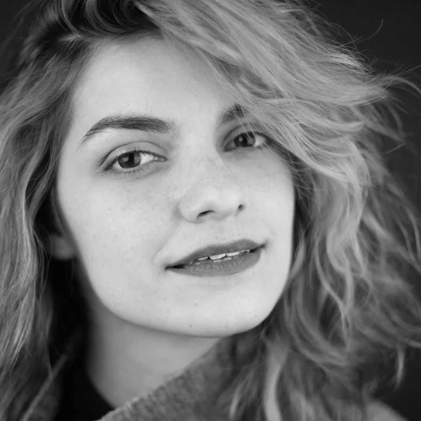 Close-up black and white photo of a young woman with wavy hair.