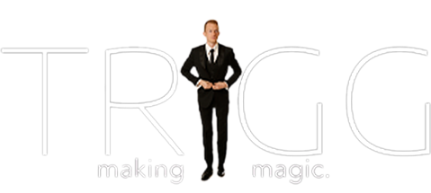 Man in a black suit in front of large white text that says "TRIGG" and smaller text that says "making magic."