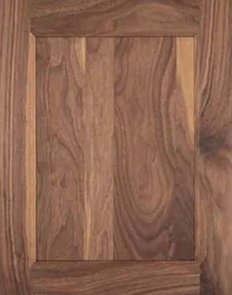 A close-up of a wooden cabinet door with a natural wood grain finish.