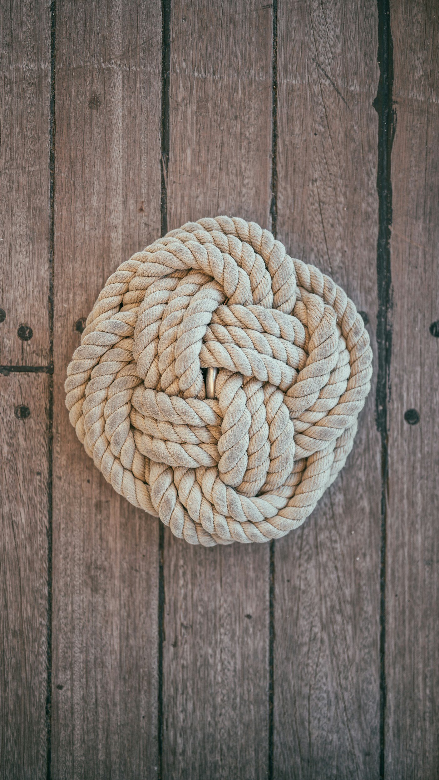 Coiled rope knot resting on a wooden plank