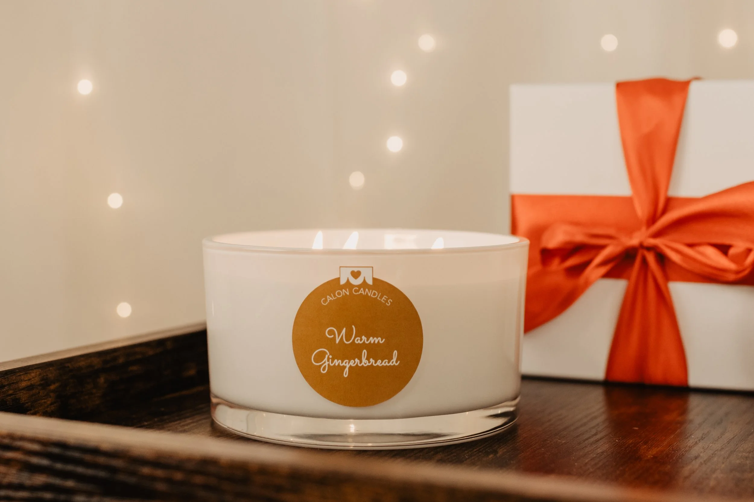 Warm Gingerbread 3-wick candle with lights and red bow.jpg
