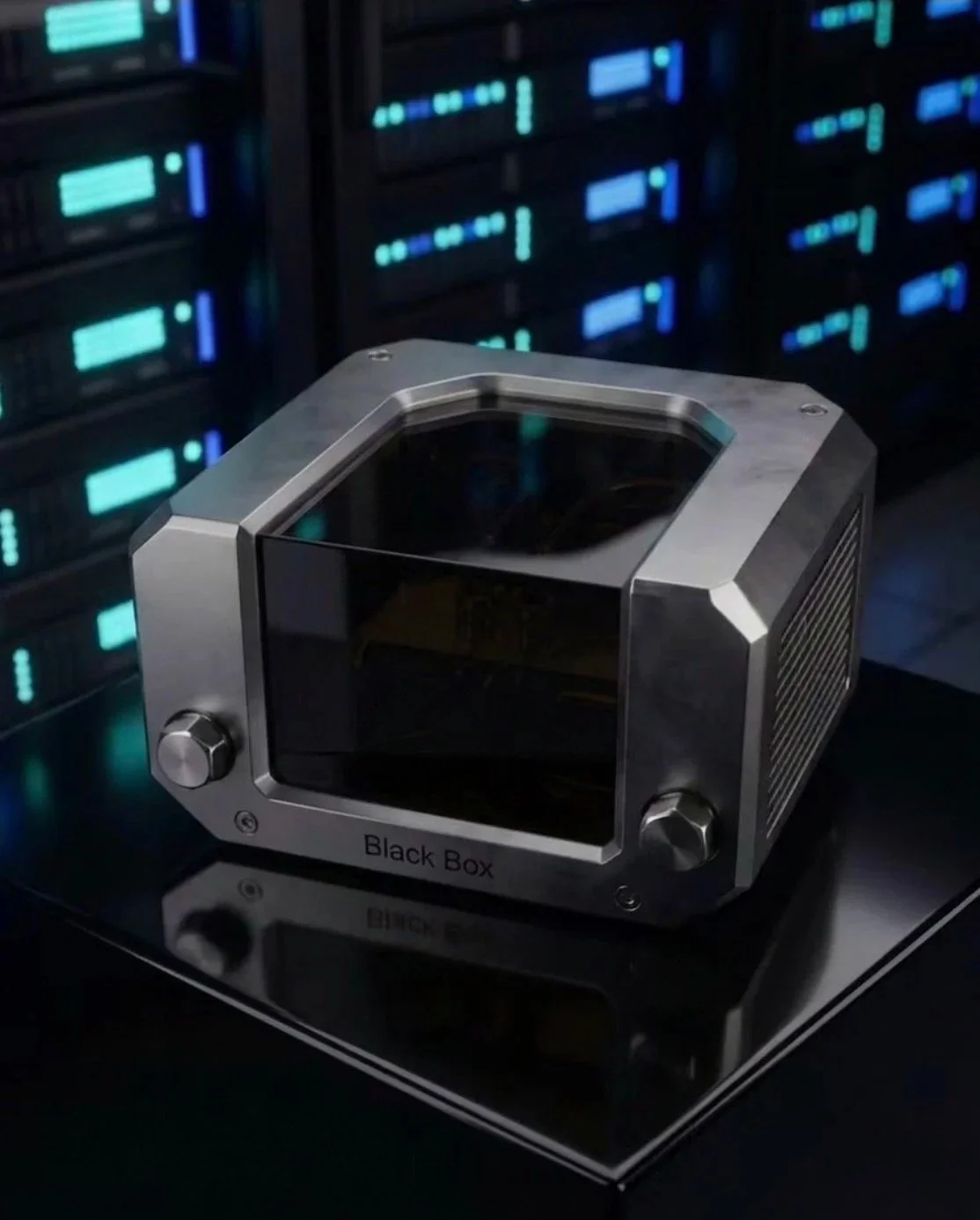 A small black box with metallic edges and knobs, labeled "Black Box," placed on a reflective surface in front of server racks with blinking blue and green lights.