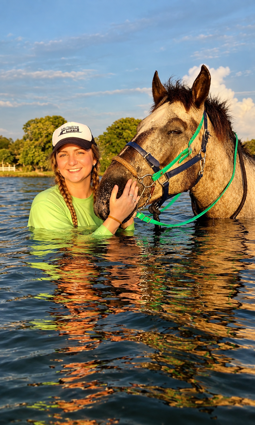 girl in water petting horse