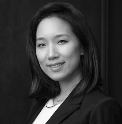 A woman with shoulder-length dark hair, wearing a blazer, smiling at the camera.