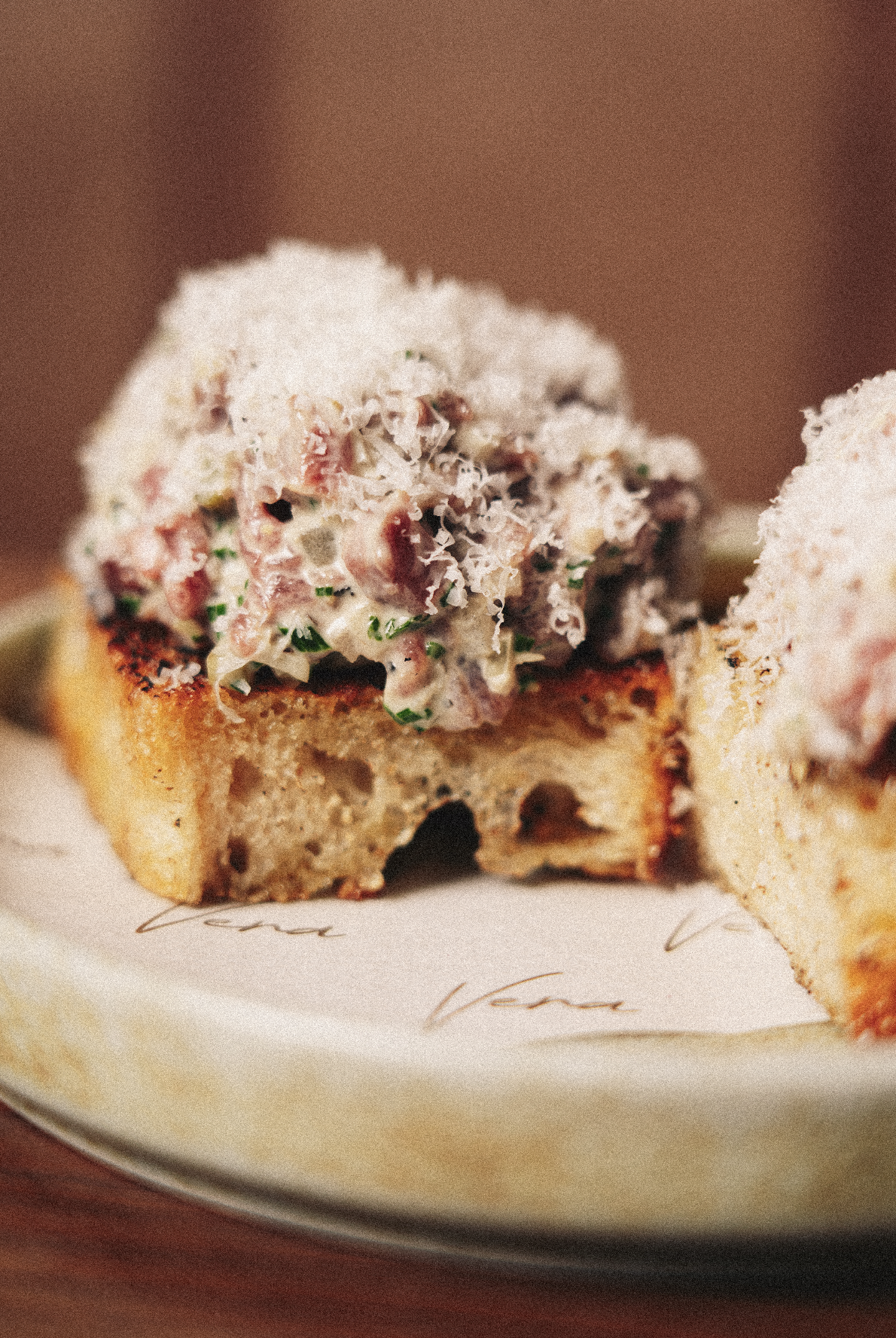 Close-up of a slice of toasted bread topped with a creamy mixture of chopped ingredients, garnished with herbs. Served at Vera Restaurant Glasgow Southside 138 Nithsdale Road.