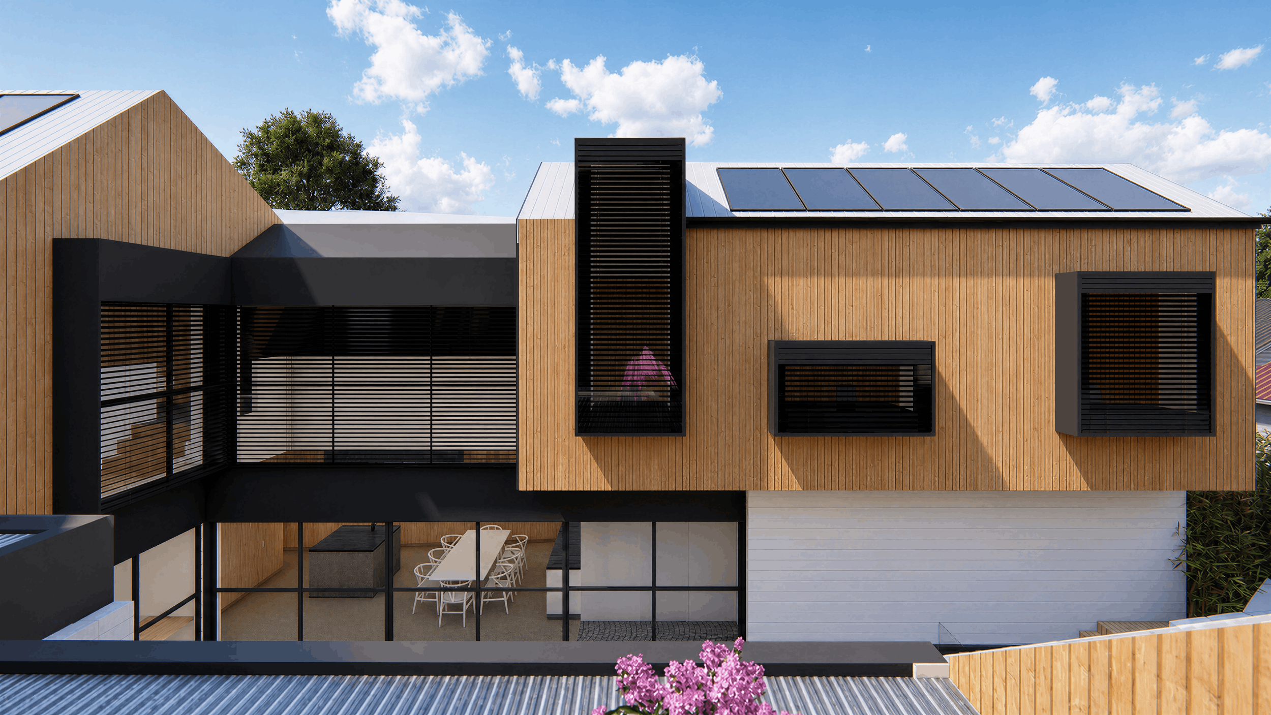 Modern house with wooden and black accents, solar panels on the roof, large windows, and an outdoor dining area beneath a balcony.