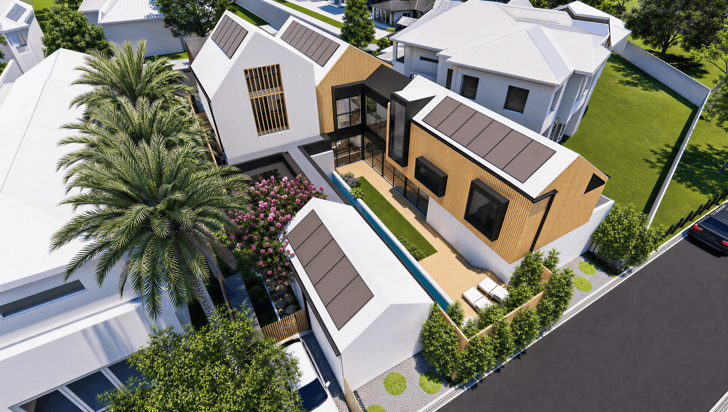 Aerial view of a modern residential property with multiple white and wooden houses, green lawns, trees, and a driveway with parked cars.