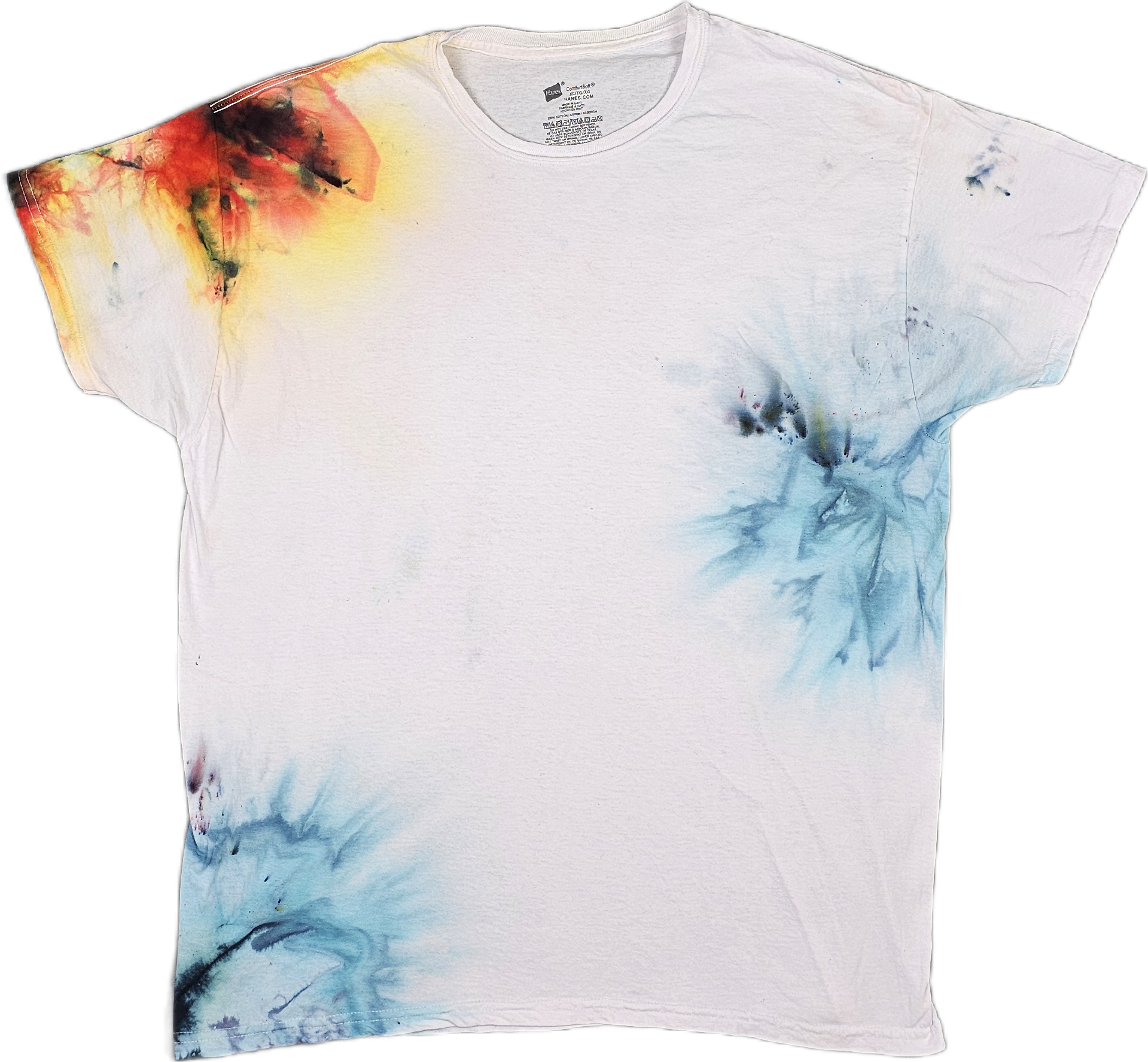 White T-shirt with colorful abstract watercolor design in red, yellow, blue, and black on the upper left shoulder and lower right side.