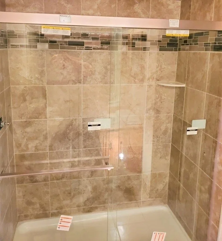Bath remodel with tiled shower walls with glass doors