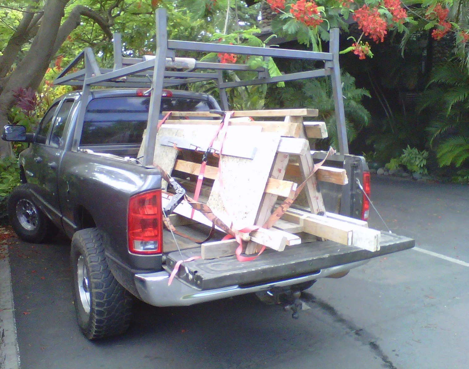 Handyman work pickup truck loaded with tools and equipment, building supplies and materials, including  wooden planks, plywood, and metal frame structures secured with straps. Used for Handyman services throughout San Francisco Bay Area