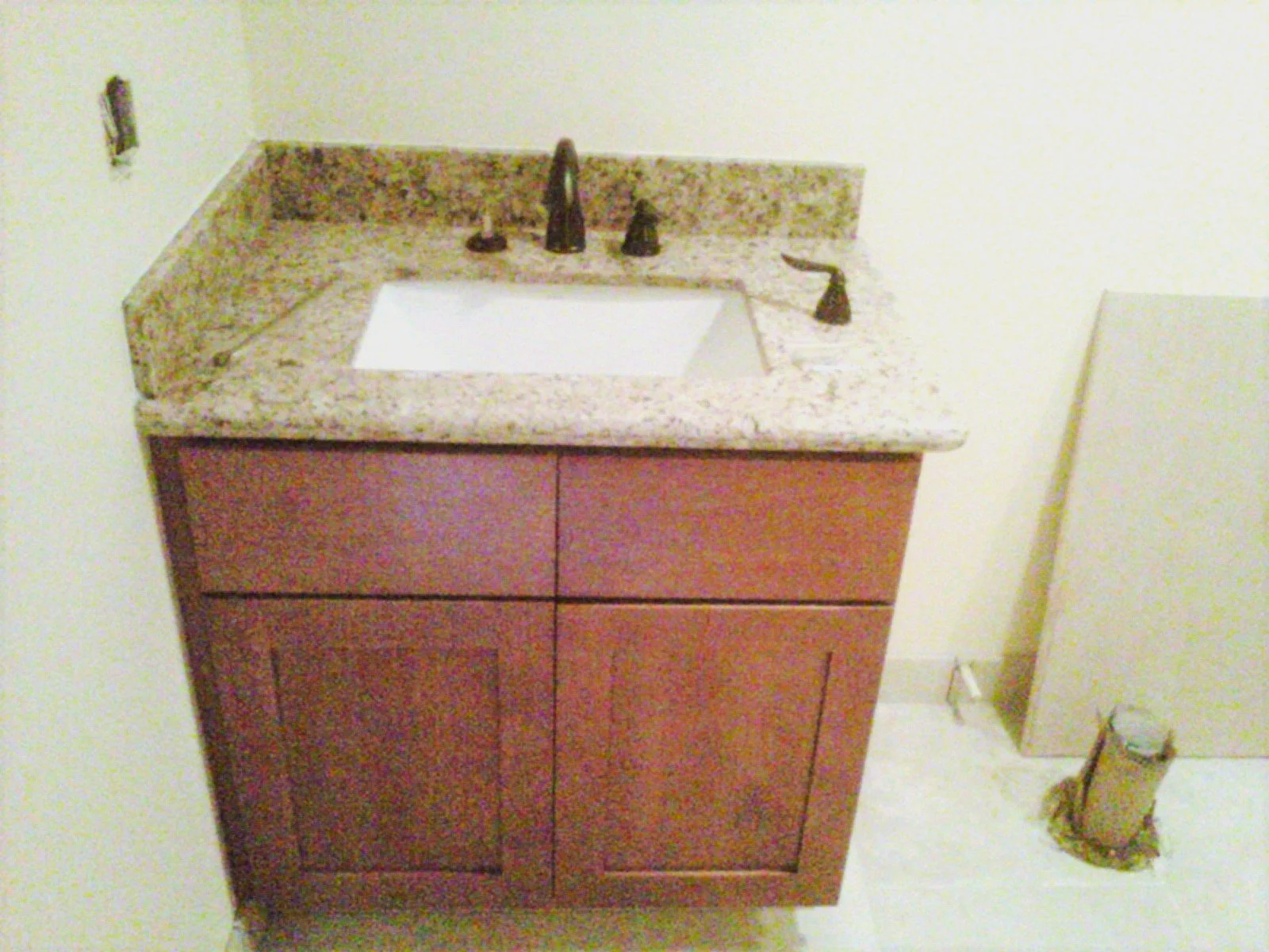Installation of new bathroom vanity with granite countertop. Minor plumbing