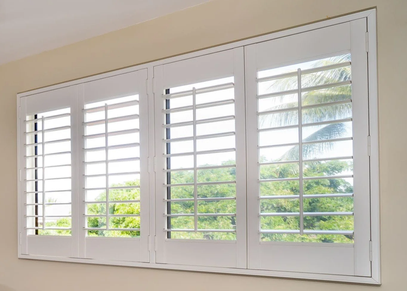 Installation of large window with custom white plantation shutters