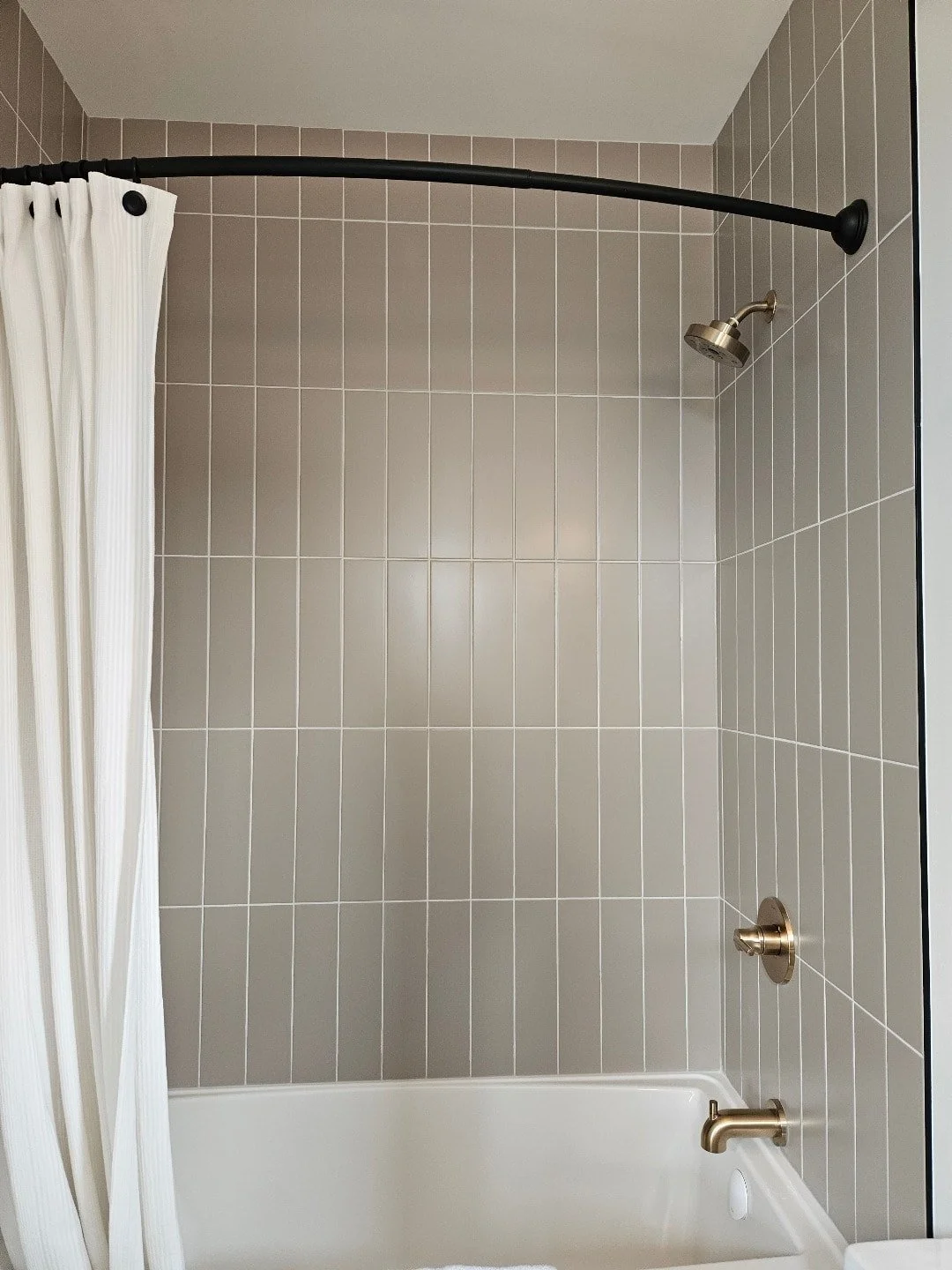Bathroom remodel with a vanity, mirror, glass-enclosed shower with tiled walls.