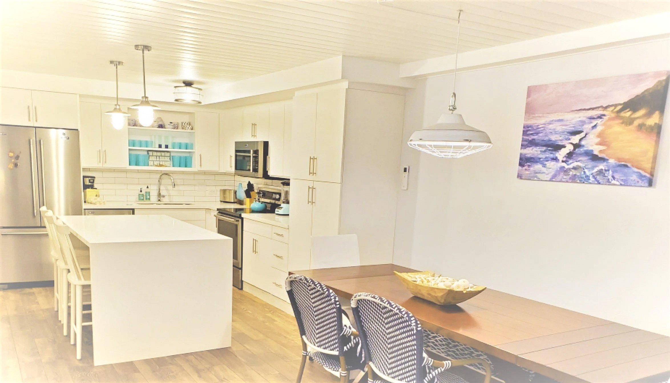 Bright, modern kitchen with white cabinets, a white island. Custom remodel