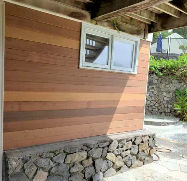 Exterior house window, wooden siding, and a stone foundation. installation