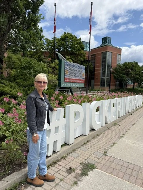 Nancy van Rooy posing alongside the #Pickeringproud sign at City Hall.