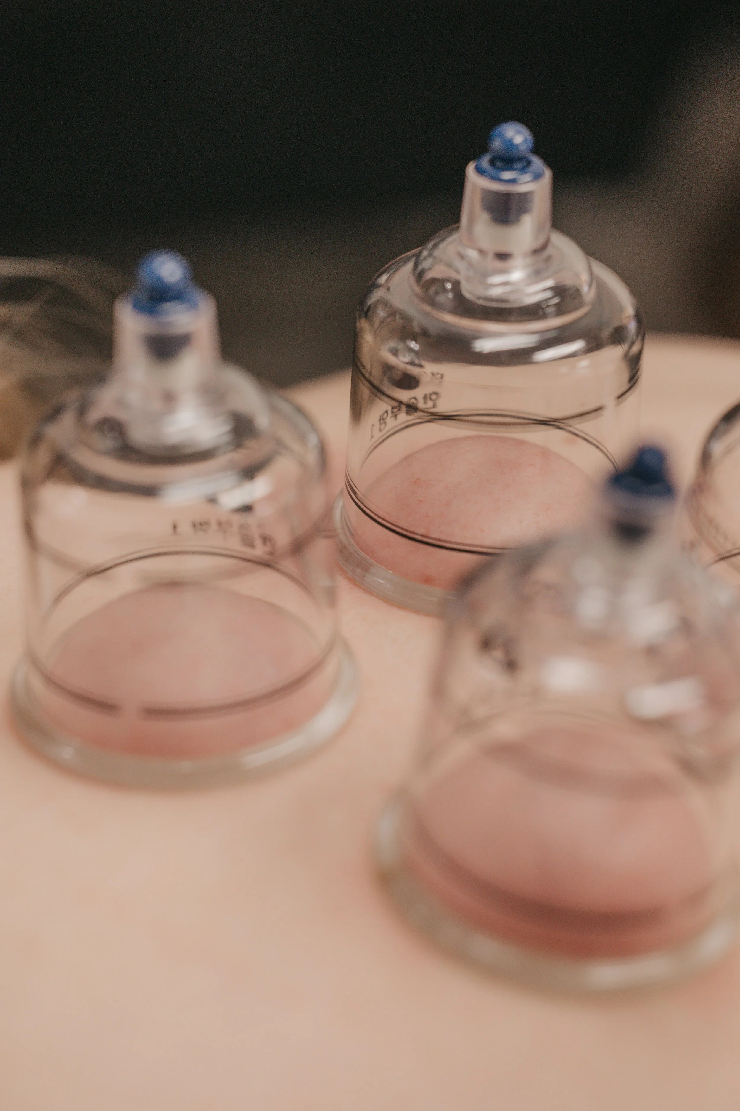 Close-up of glass vials or ampoules with blue caps on a light-colored surface.