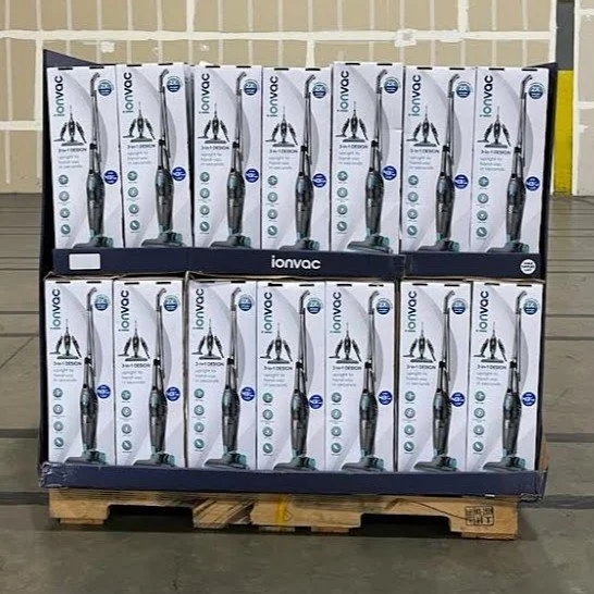 Display of vacuum cleaners on a pallet in a warehouse.
