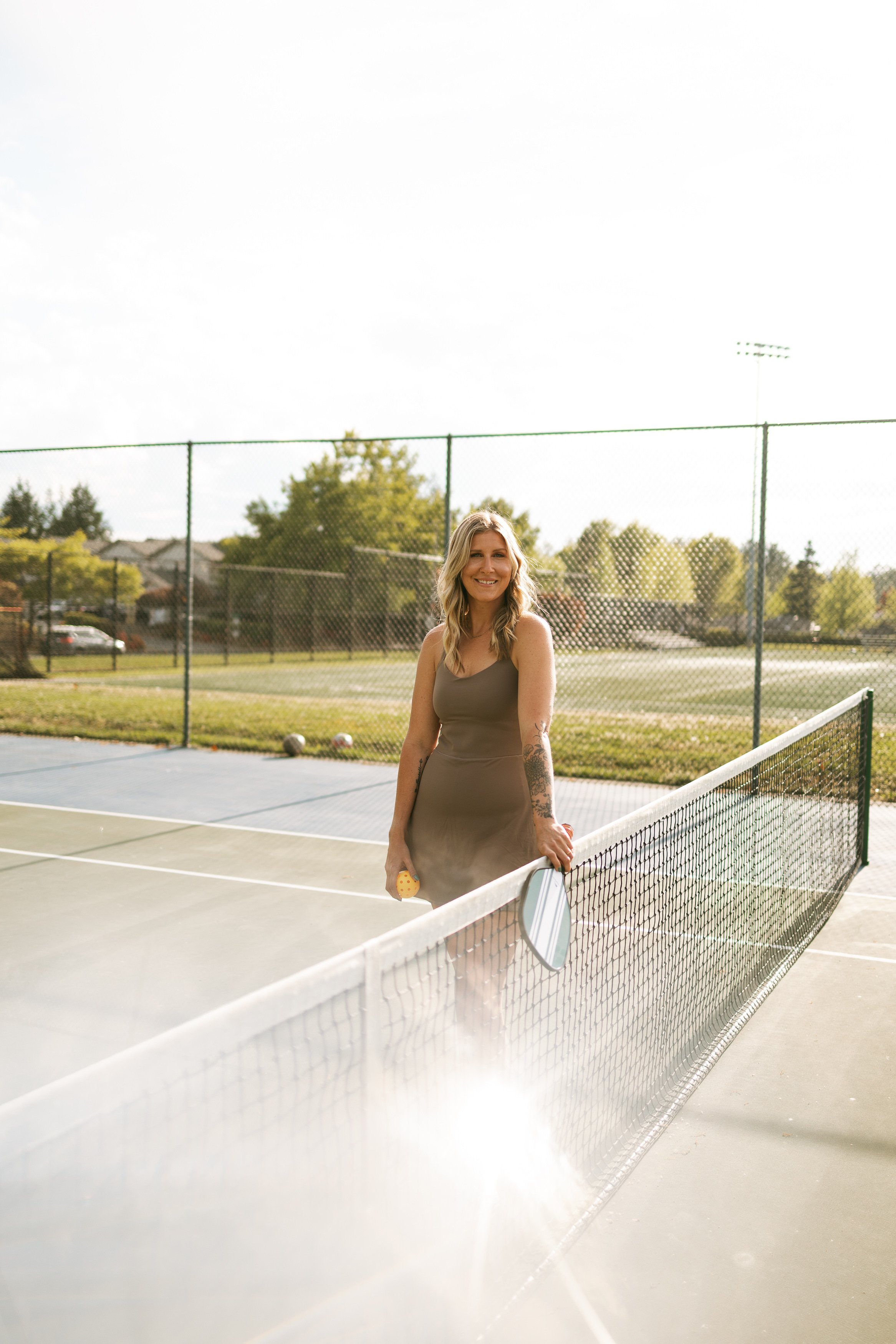 Malia Reynolds, blonde hairstylist and colorist behind Wildewood Hues, on a pickleball court in Lynden, Washington