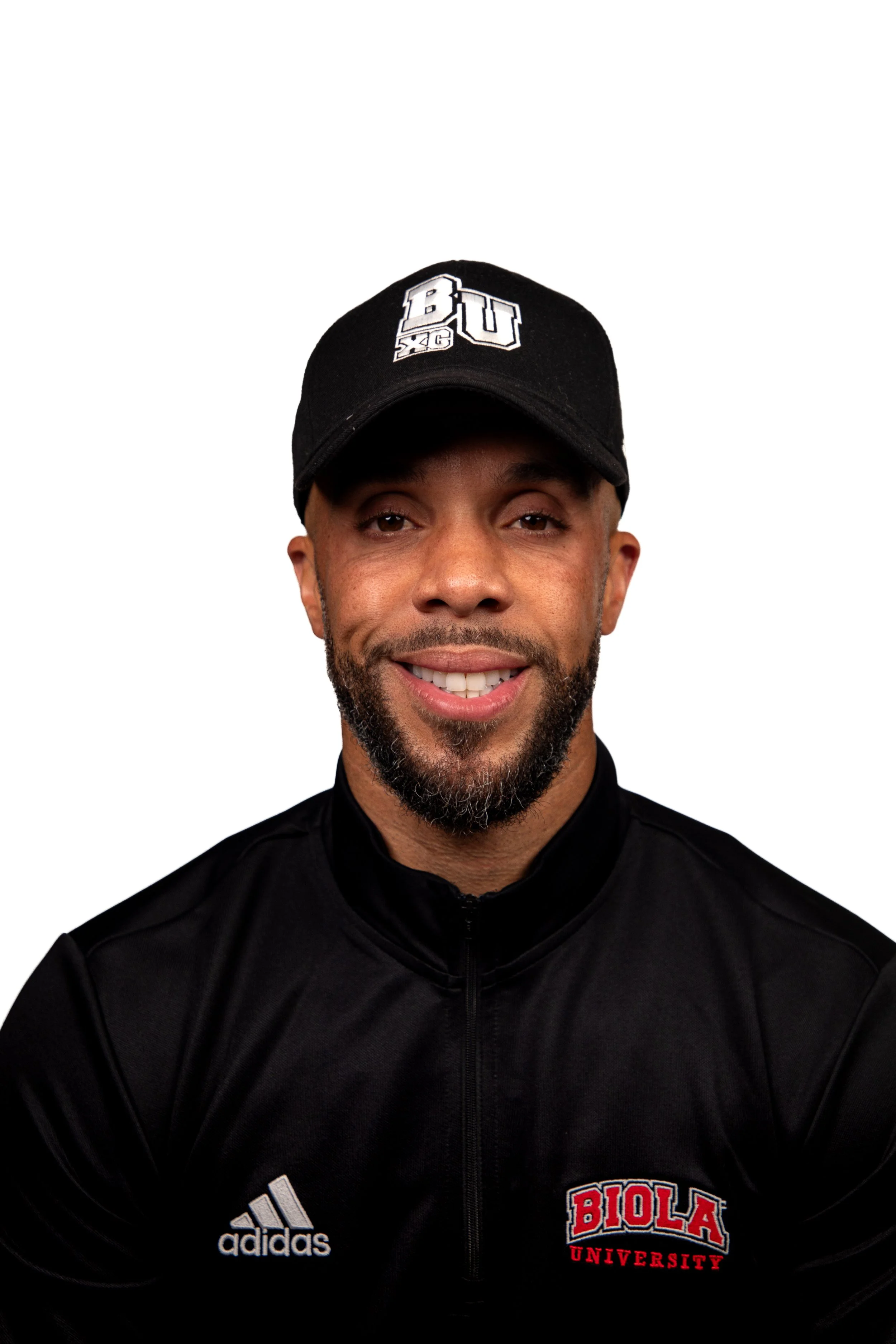 A man smiling, wearing a black Adidas jacket and a black cap with 'BU XC' logo, standing against a plain white background.