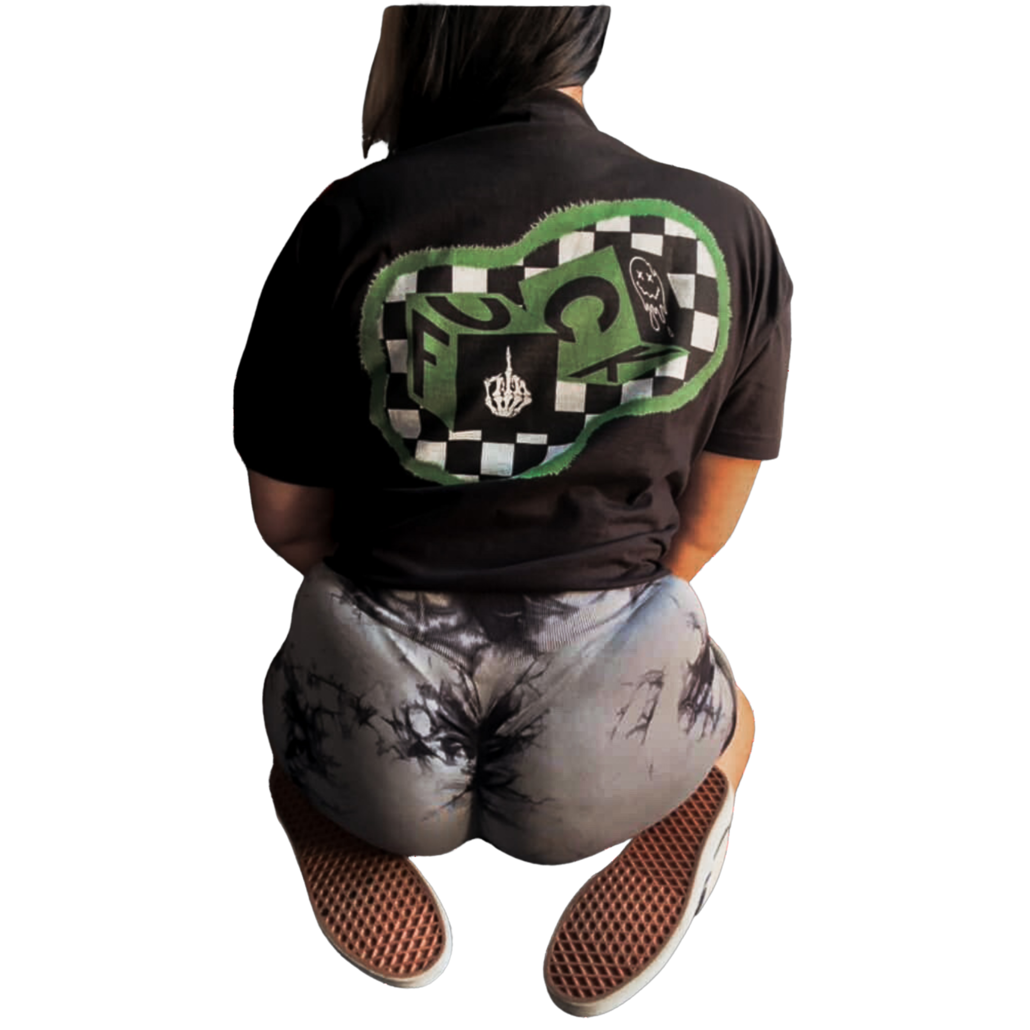 Person wearing a black jacket with a green and white checkered patch and a small smiling face patch on the back, tan snake skin patterned shorts, and fishnet sleeves.