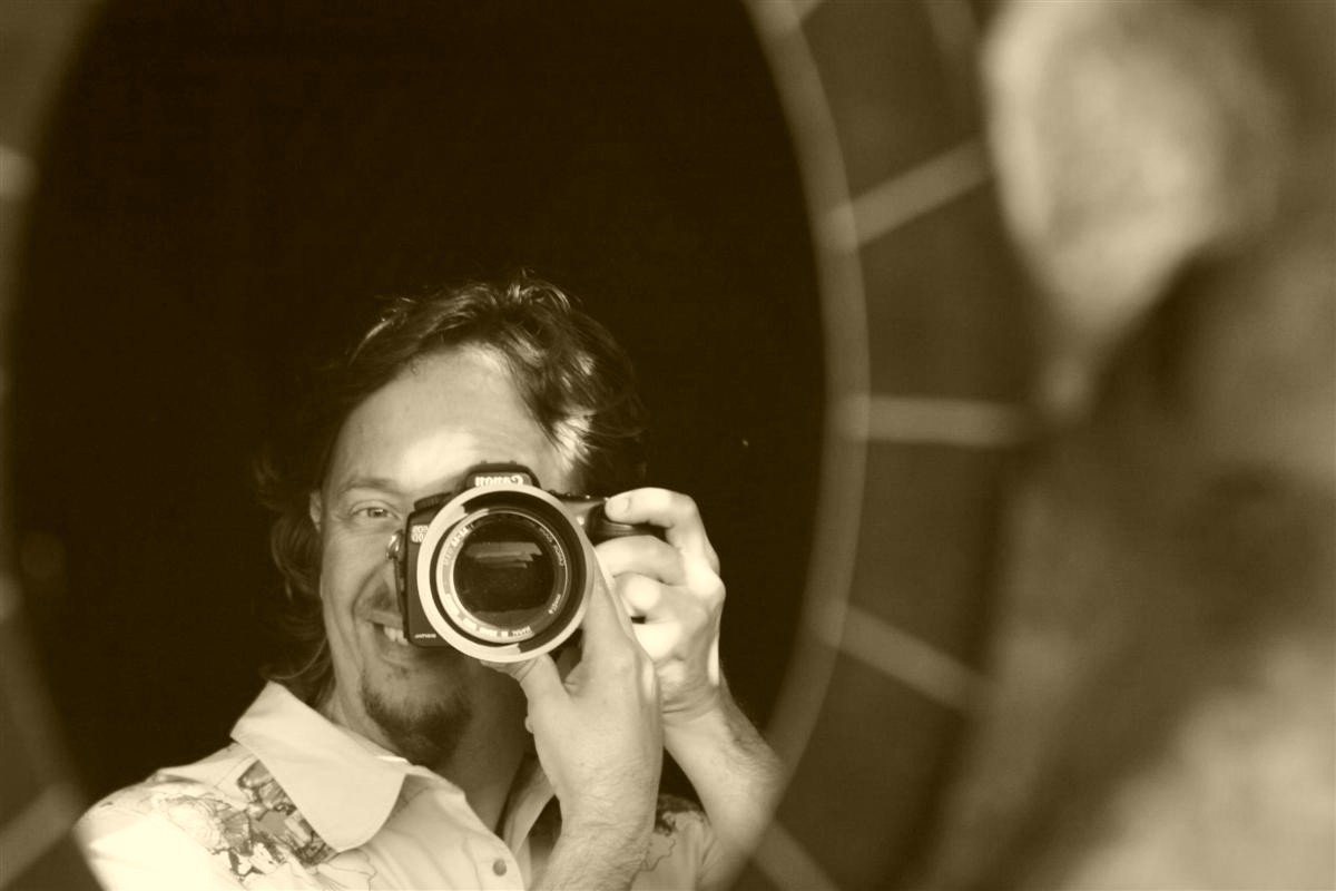 A man taking a selfie with a camera in front of a mirror.
