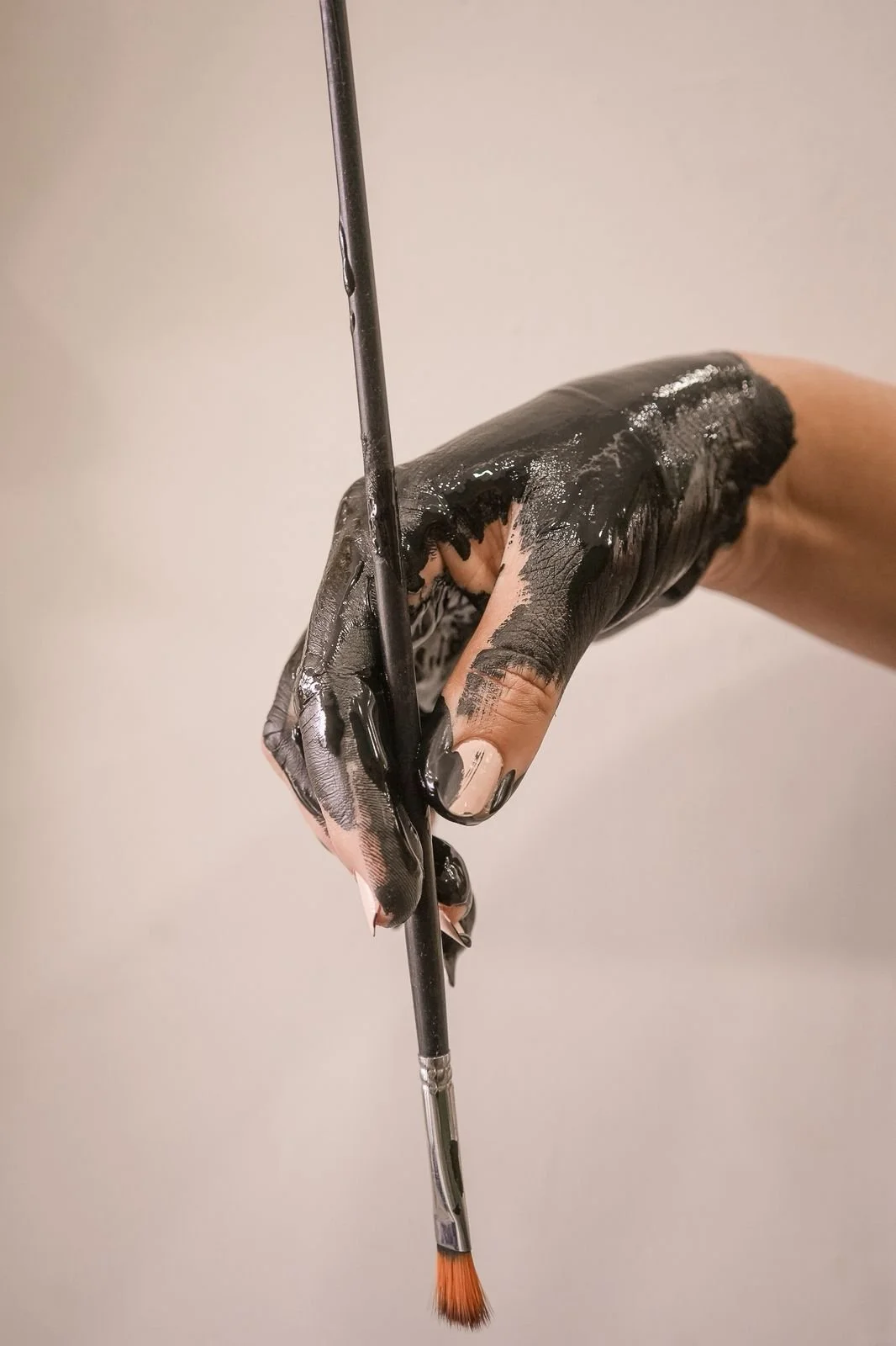 Mano pintando con pintura negra usando un pincel