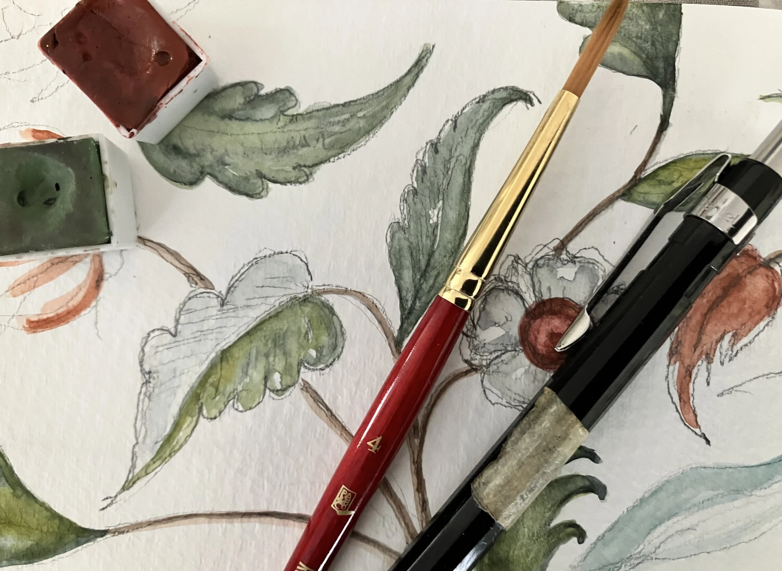 Watercolor painting of green leaves and orange flowers, with watercolor brushes and pens resting on the artwork.