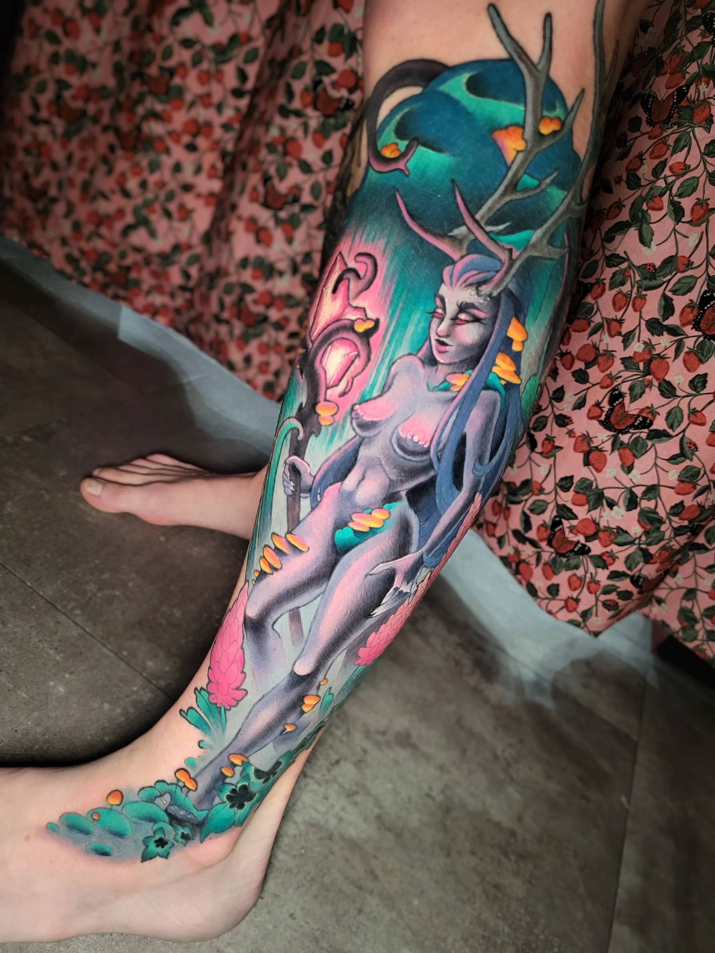 Colorful tattoo sleeve featuring a mythical creature resembling a unicorn or horse with a horn and antlers, surrounded by vibrant abstract and natural elements, on a person's arm.