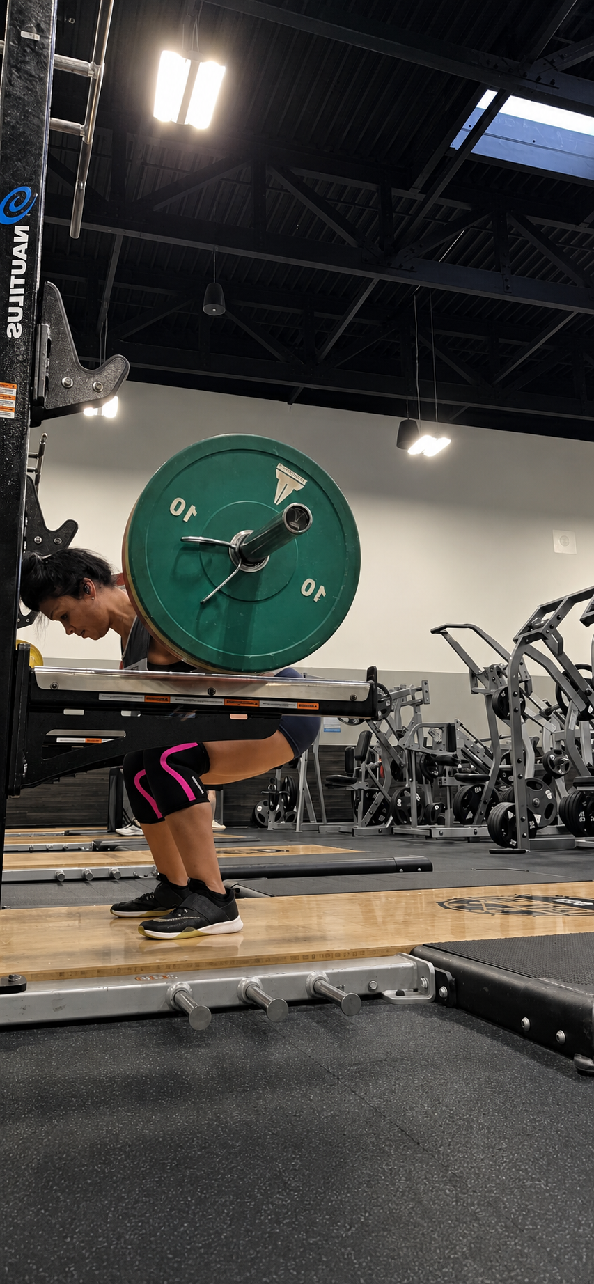 Client performing a heavy barbell back squat during a Tapia Training session