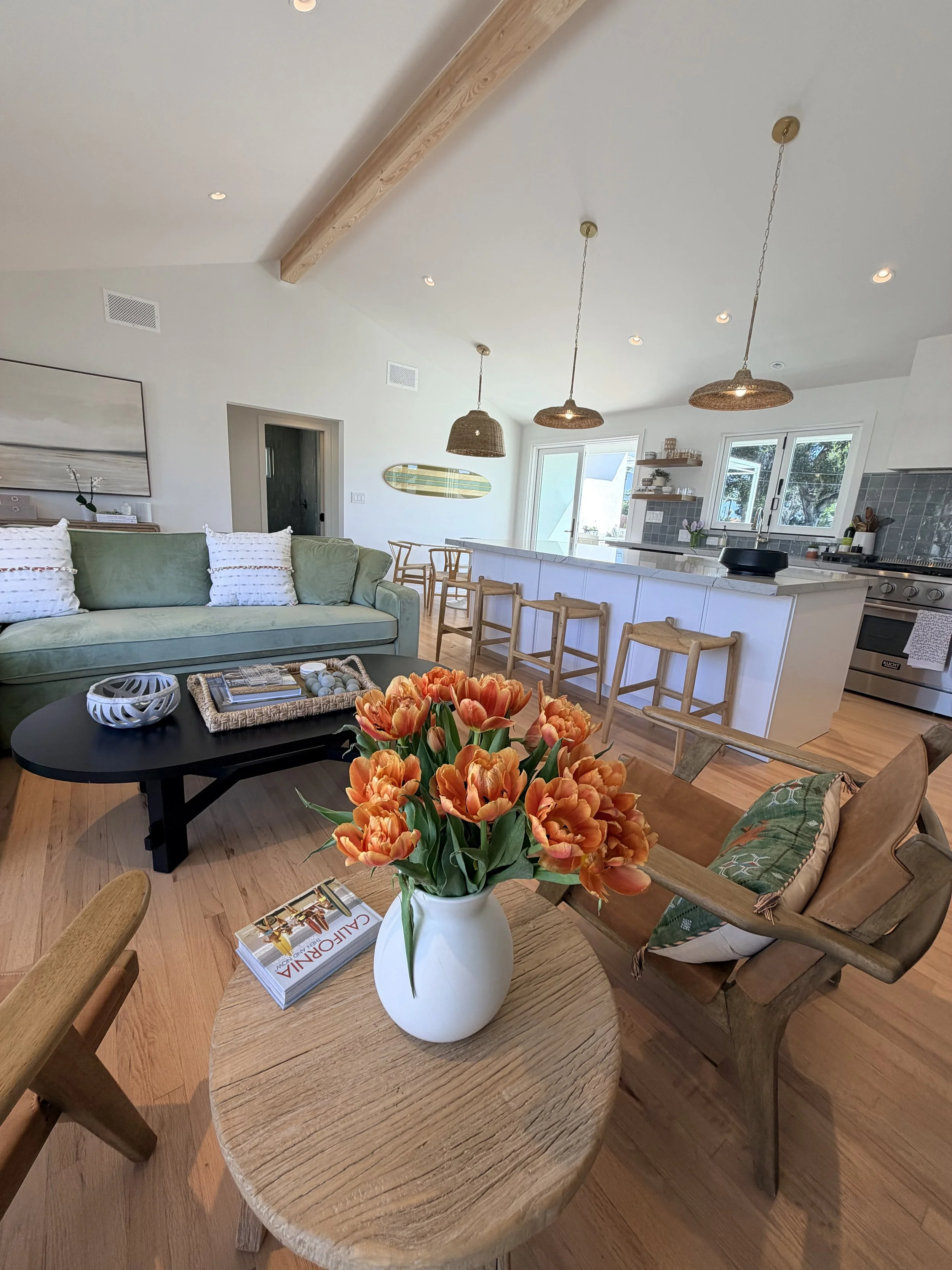 Light-filled Santa Barbara home with open kitchen, wood beams and orange tulips
