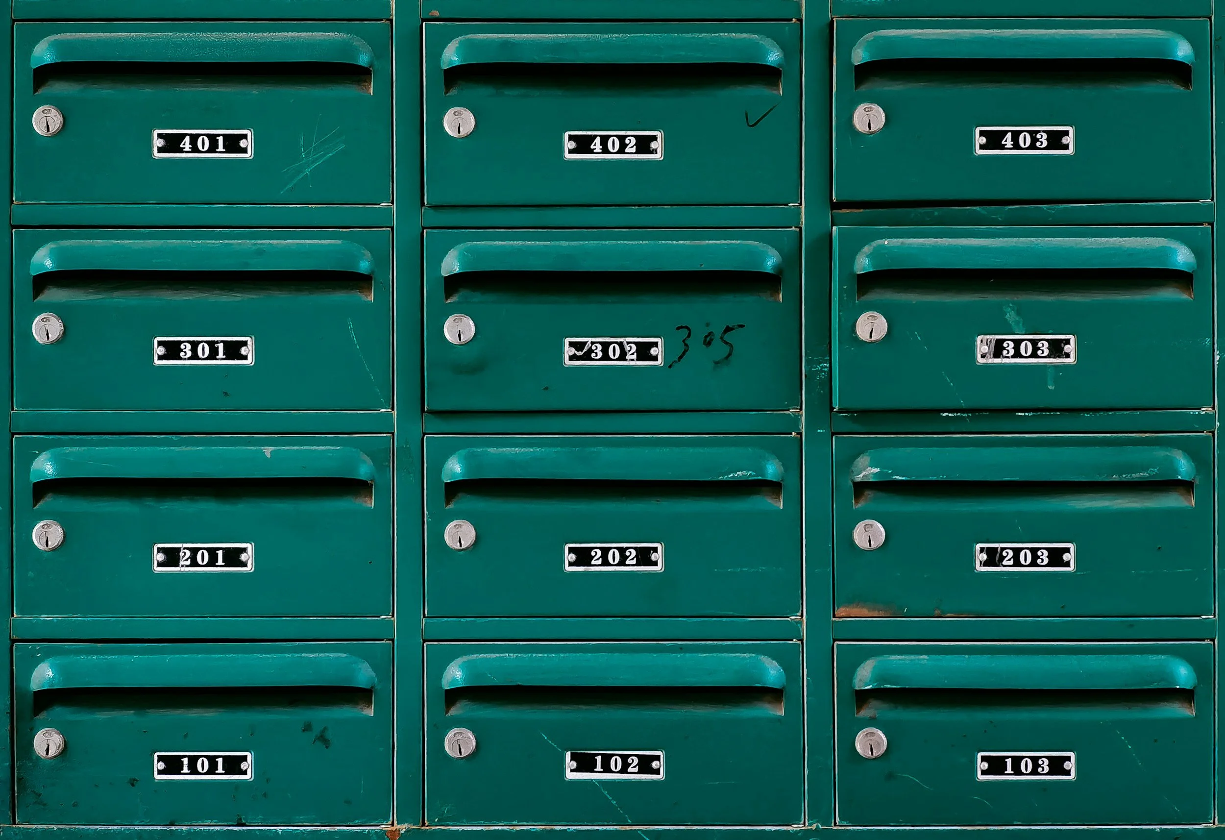 Green postal mailboxes with numbered labels from 101 to 403, arranged in a 3 by 4 grid.