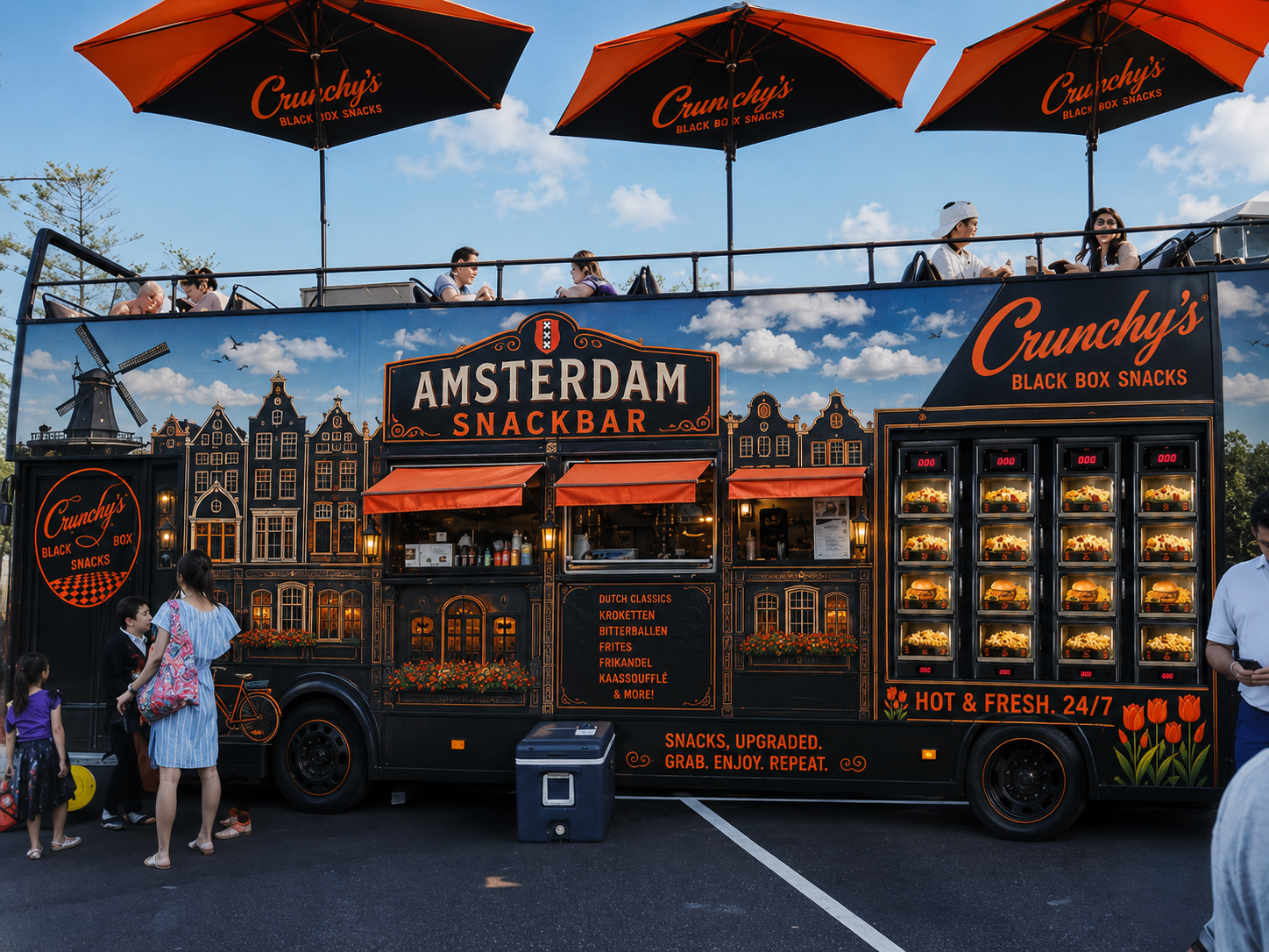 Black mobile food truck with orange and white signage advertising 'Amsterdam Snackbar,' 'Crunchy's Black Box Snacks,' and various Dutch snack items, parked on a street with children and adults nearby, with a blue sky and trees in the background.