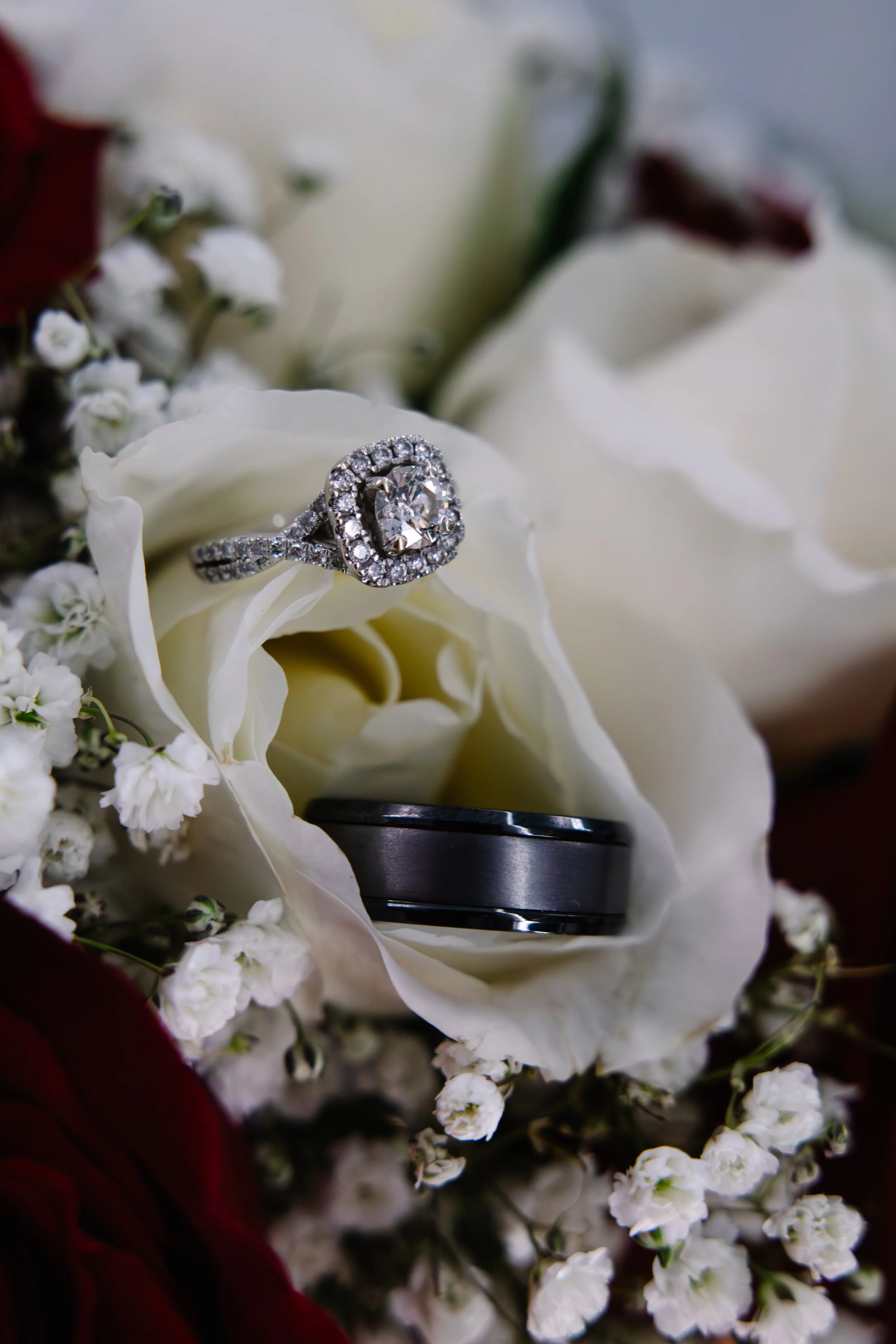 Close-up of a diamond engagement ring resting on white flowers.