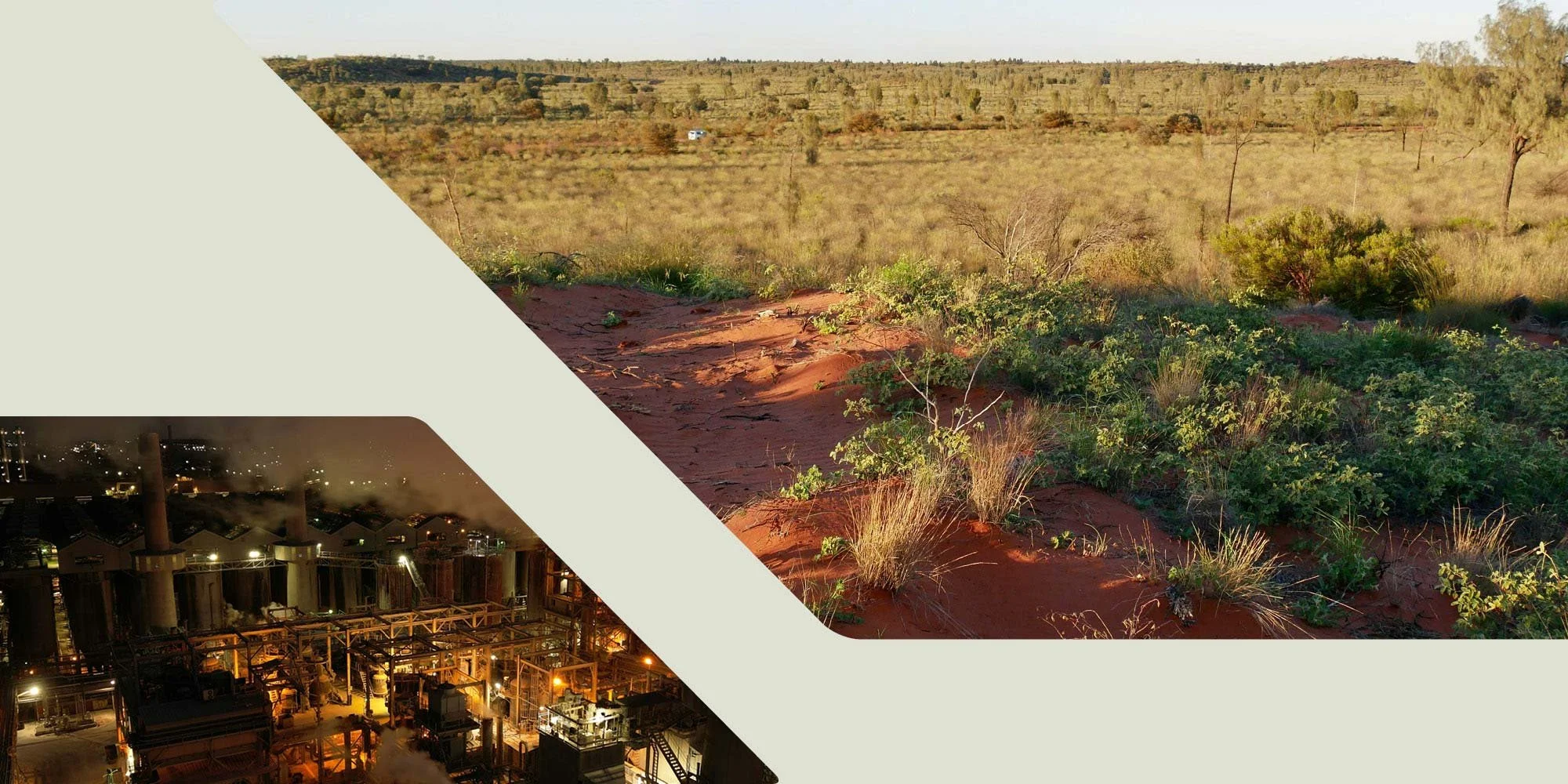 A landscape view with dry, reddish soil and sparse green vegetation in the foreground. The background features a wide expanse of grassy, semi-arid terrain with scattered bushes and small trees, under a clear sky.