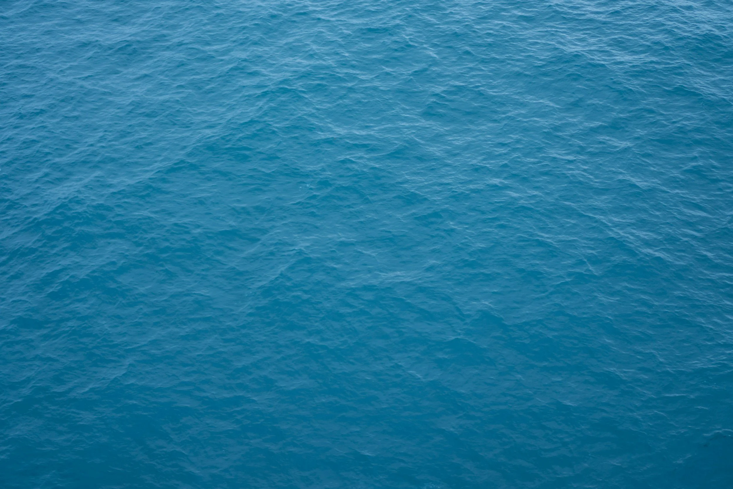 Blick auf das offene Meer mit blauer Wasseroberfläche und kleinen Wellen.