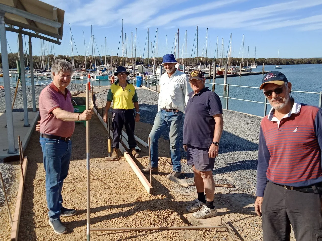 People standing around, smiling at the camera at the boat club