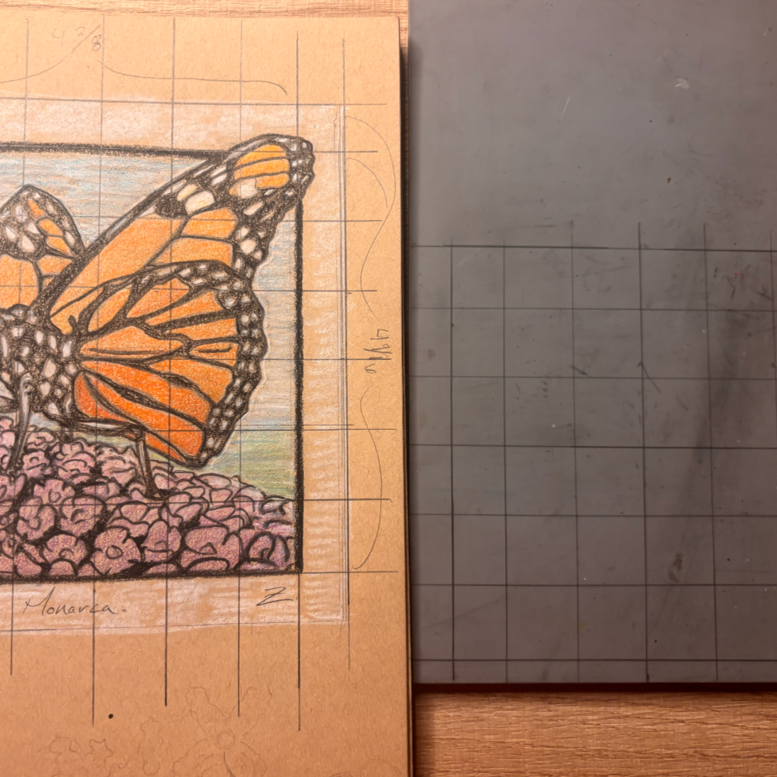 A grid drawing of a monarch butterfly with orange and black patterned wings resting on pink rocks, mounted on a tan background with grid lines for coloring.